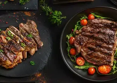 Two beautifully grilled steak platters with garnishes on a dark background.